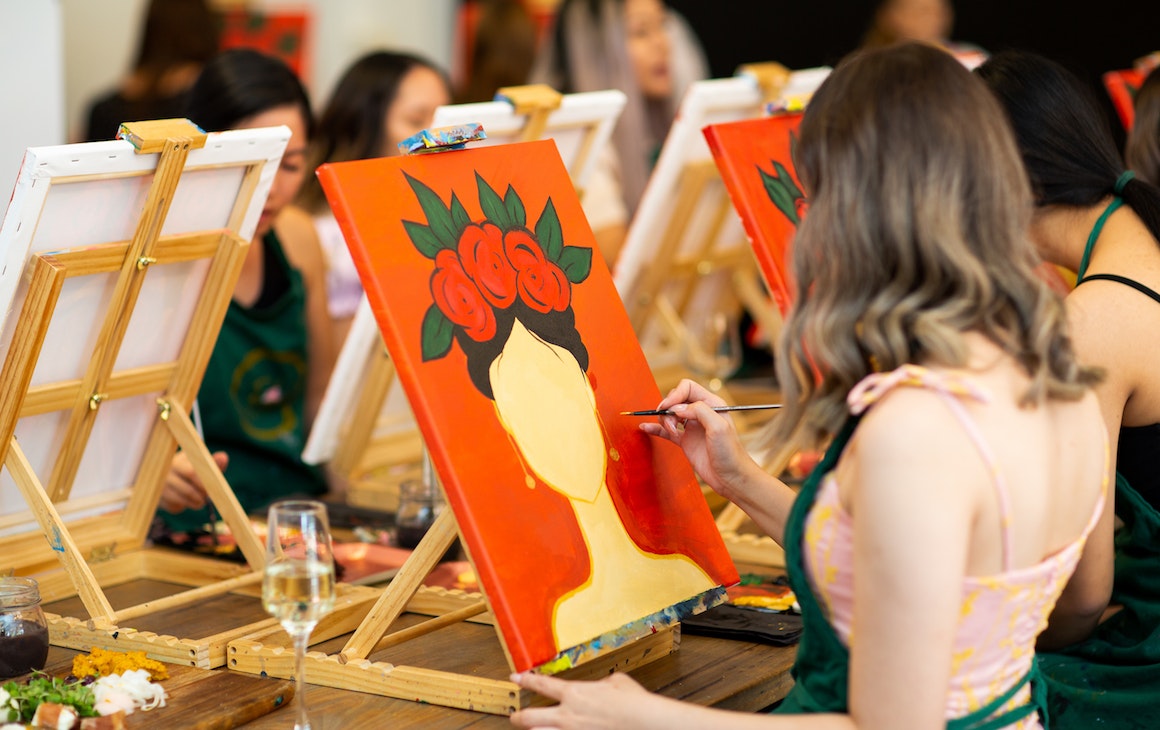 someone painting at a paint and sip class